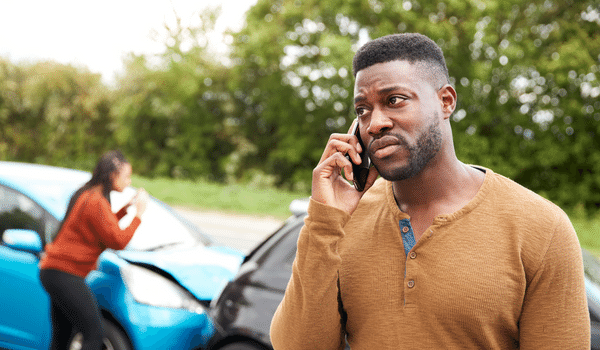 commercial auto insurance companies in oklahoma - man on the phone in front of a car crash